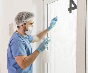 male-nurse-disinfecting-windows-hospital